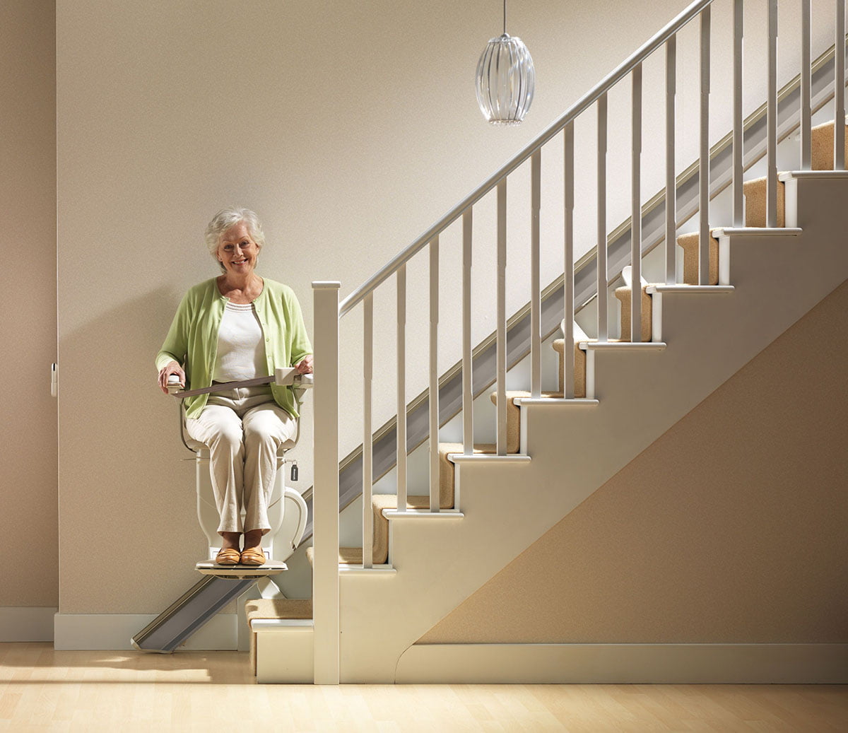 a women sitting on a stairlift and smiling