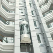 Modern glass shaft with Energy-Efficient Elevators inside a high-rise building showcasing a sleek, futuristic vertical transport system.